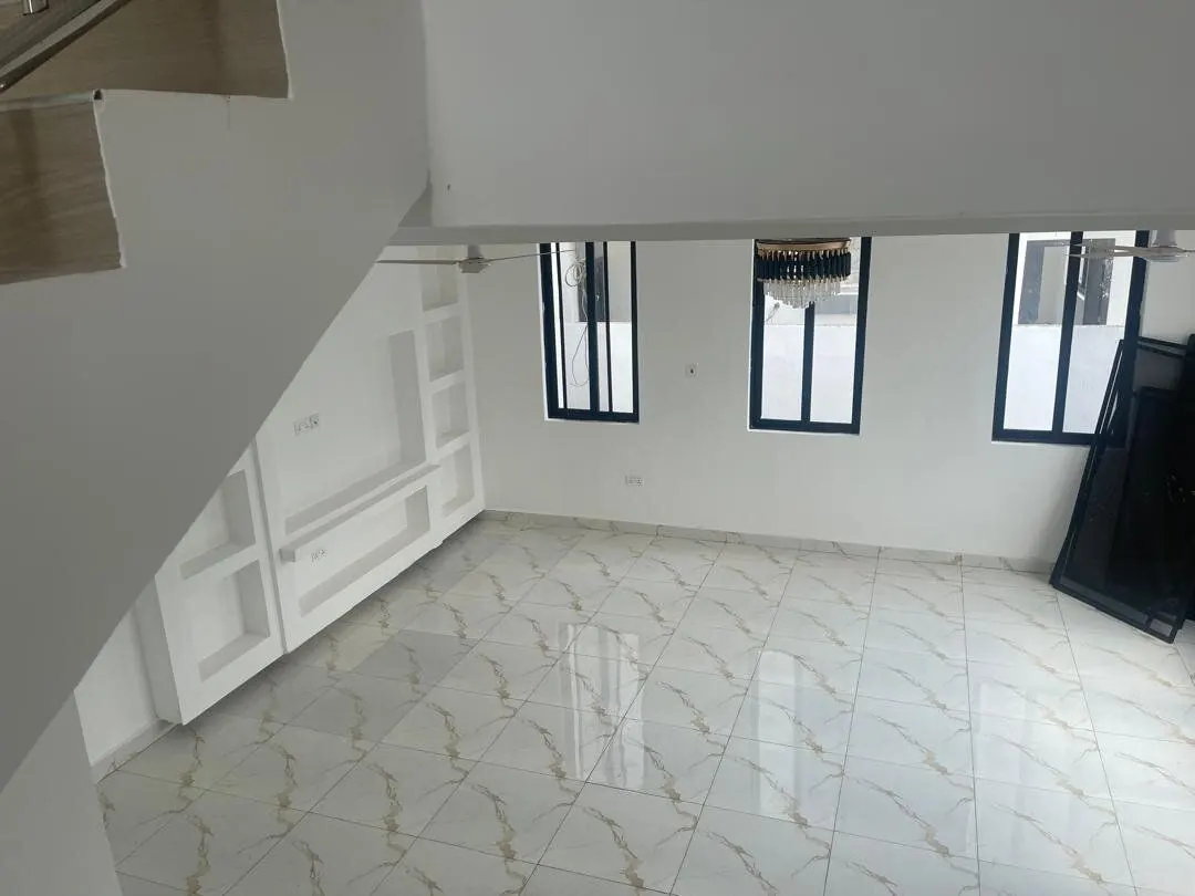 Open-plan living room with marble flooring and built-in shelving