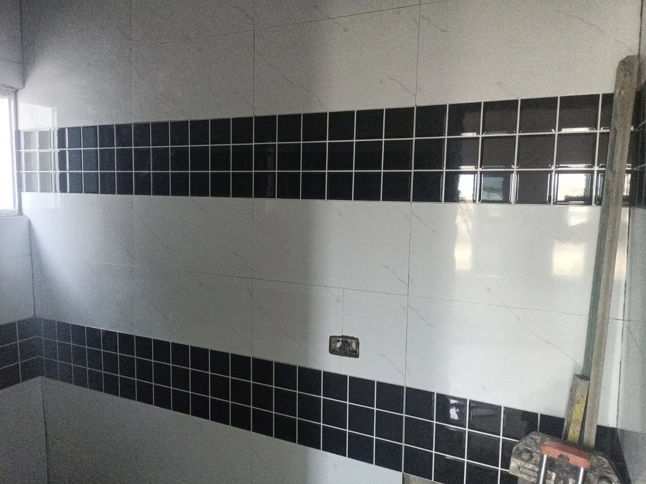 Detailed black and white tile work in a finished bathroom